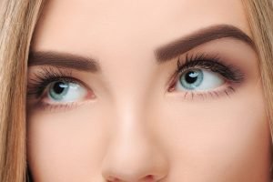 close-up face of pretty girl with beautiful big blue eyes, big eyelashes and eyebrows