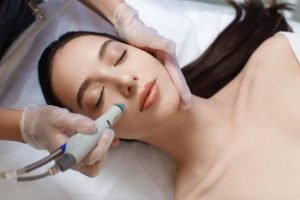 Professional female cosmetologist doing hydrafacial procedure in Cosmetology clinic. Doctor use hydra vacuum cleaner. Rejuvenation And Hydratation. Cosmetology