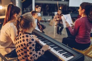 Group of kids teaching to play instruments in music school