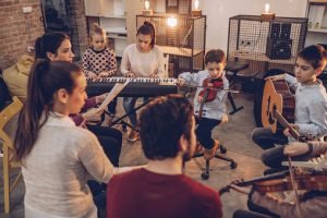 Group of kids teaching to play instruments in music school